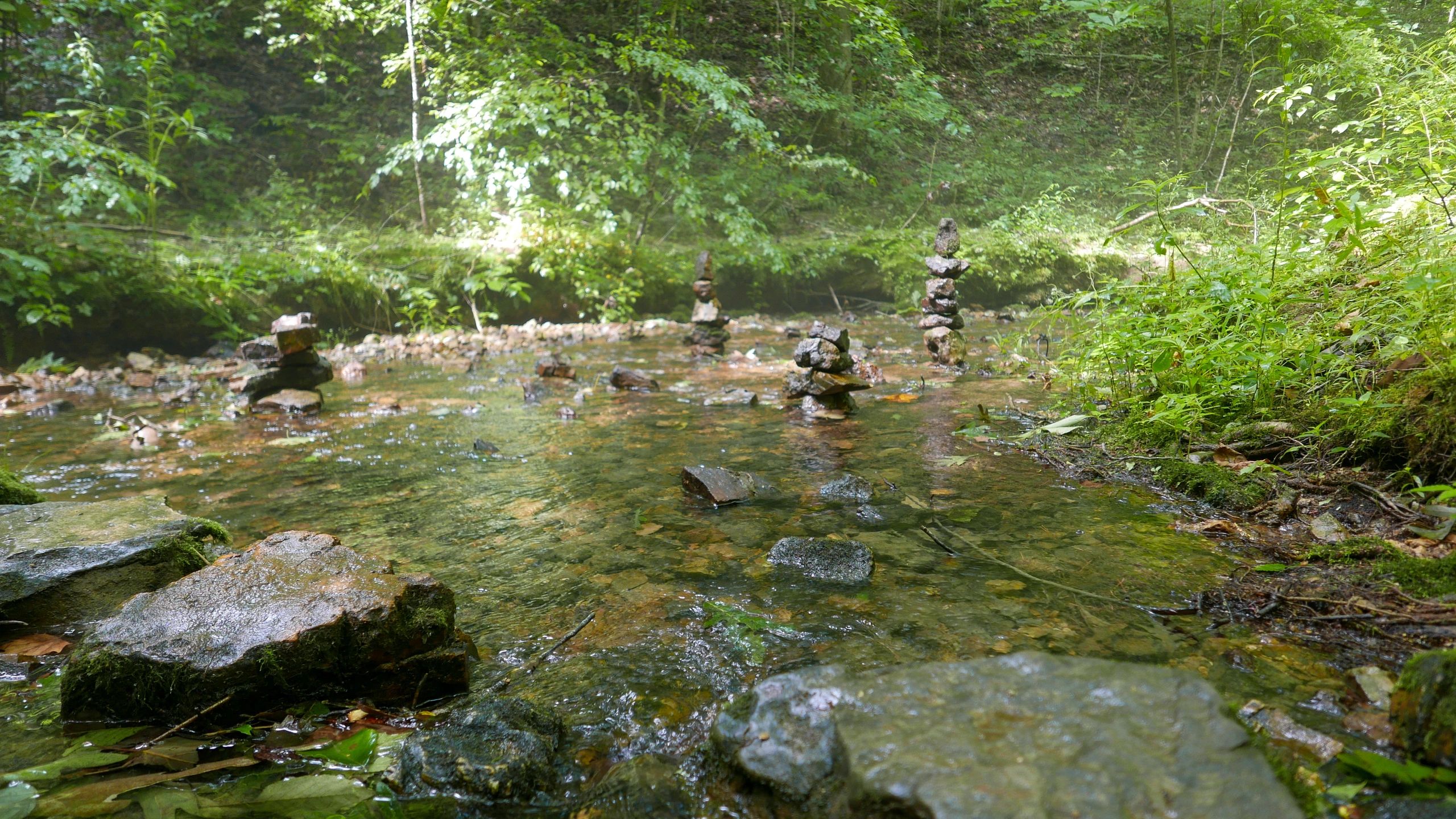 Natural stones and flowing water suggesting a serene hot spring setting